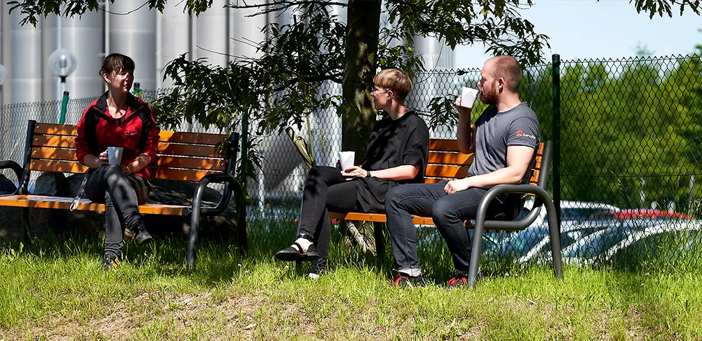 Junge Gerodur Mitarbeiter sitzen in Ihrer Pause im Gerodur Außengelände